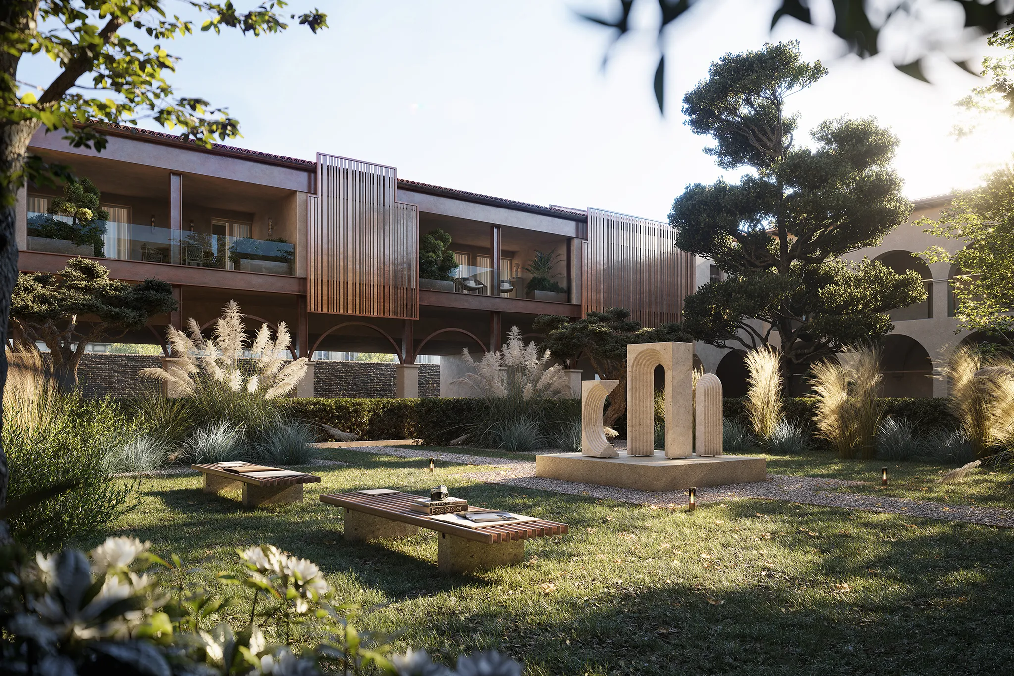 Sunlit courtyard garden with two wooden benches, modern arch-shaped stone sculptures, lush greenery, and a two-story building with balconies in the background.